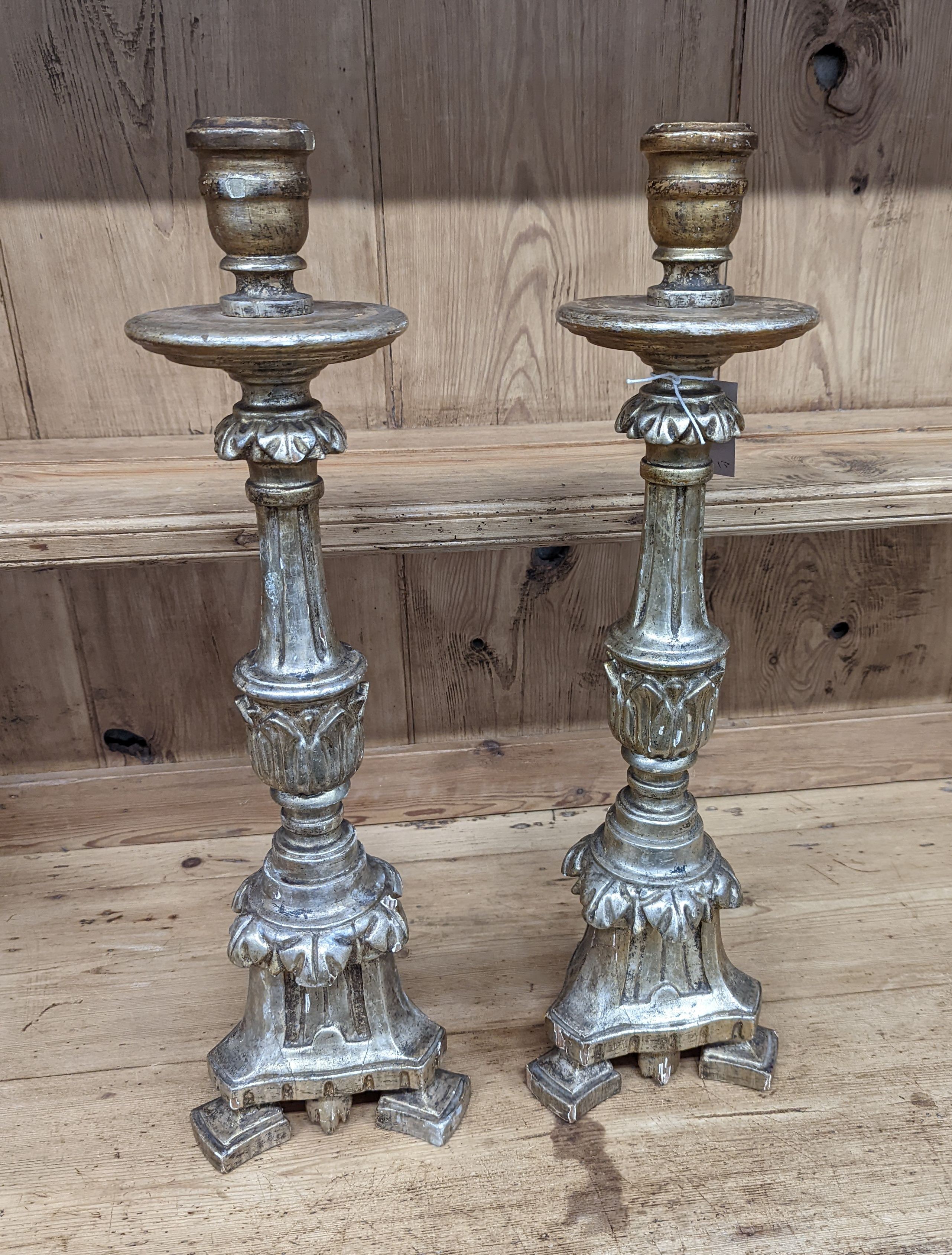 A pair of 18th century style carved silvered wood candlesticks, height 58cm